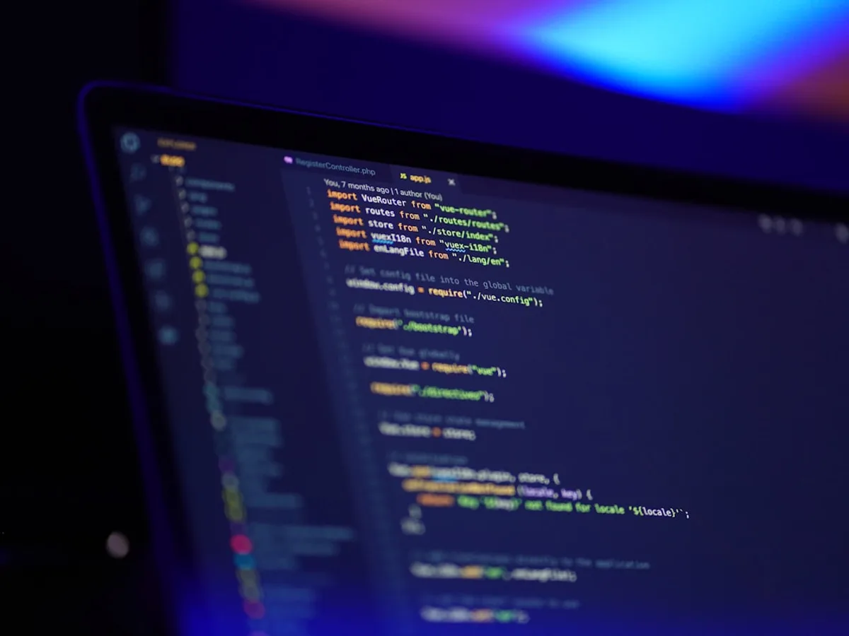 Close-up of a laptop screen showing colorful lines of source code, representing GiveTurn's software development service